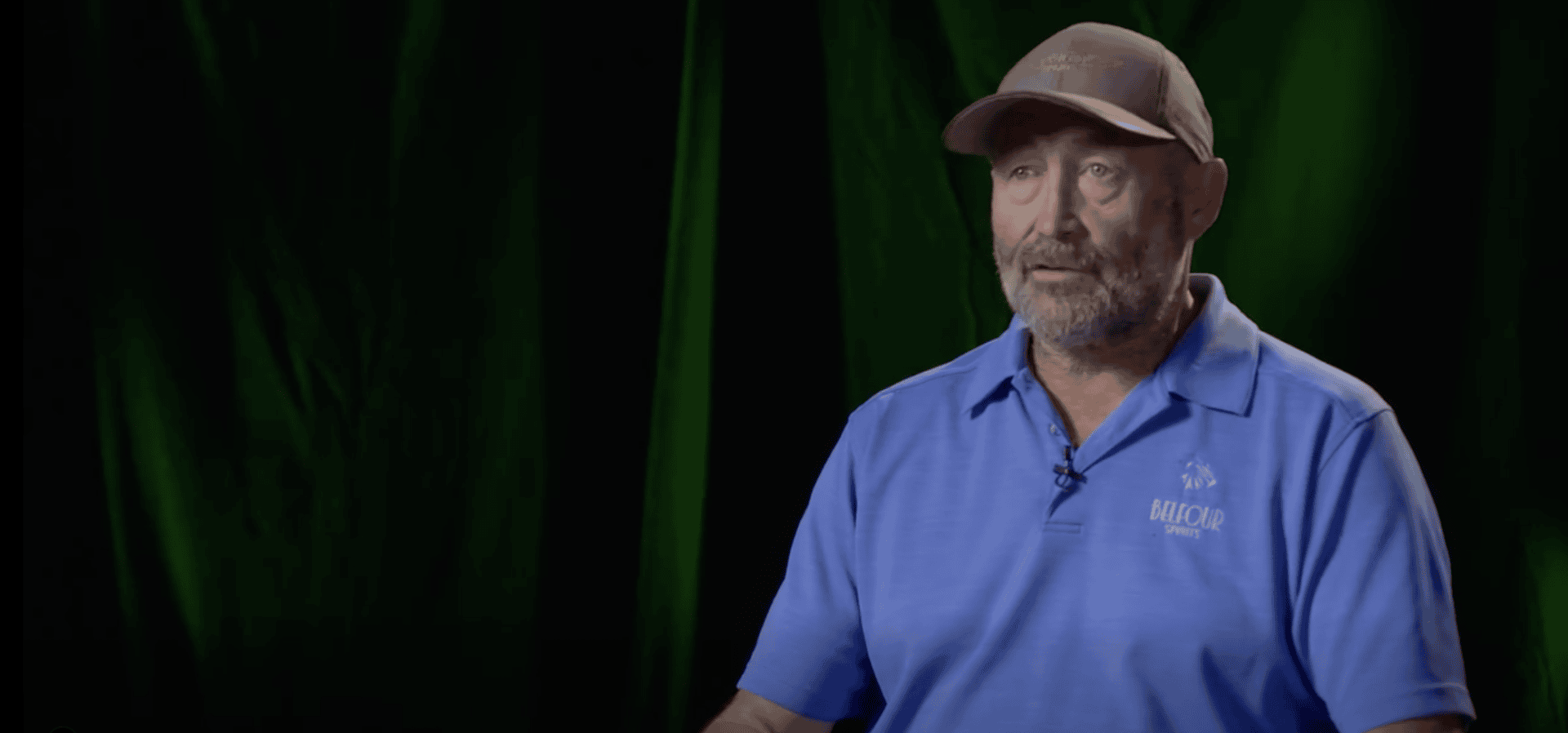 Bearded man in blue polo and cap